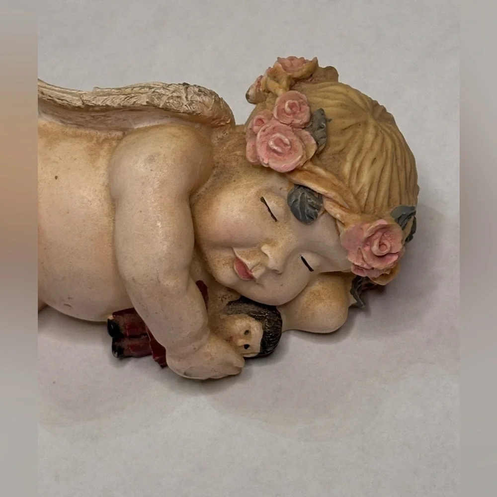 Sleeping Cherub Figurine holding a doll with Floral Crown